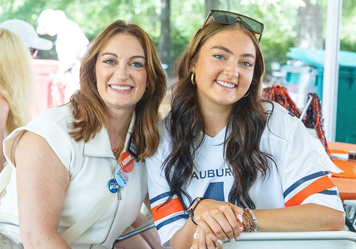 Two men wearing Auburn-themed clothing are smiling and posing together outdoors.