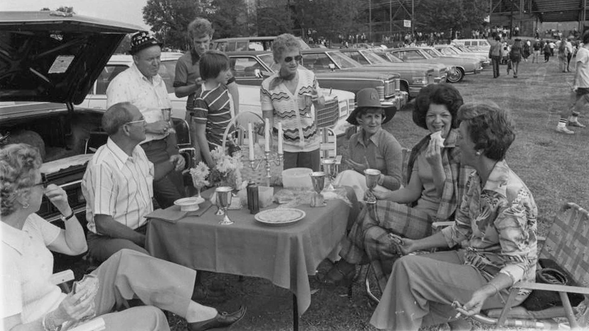 Former Auburn trustee Sue Fincher ’51 stands at the head of a table adorned with candelabra, silver goblets and bone china during a 1978 tailgate.